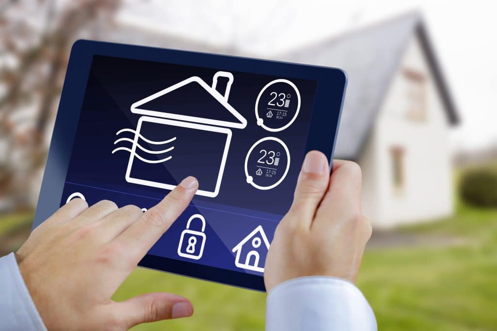 Ein Mann, der einen Tablet-PC vor dem Hintergrund eines Hauses benutzt